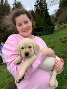 Girl holding yellow lab puppy